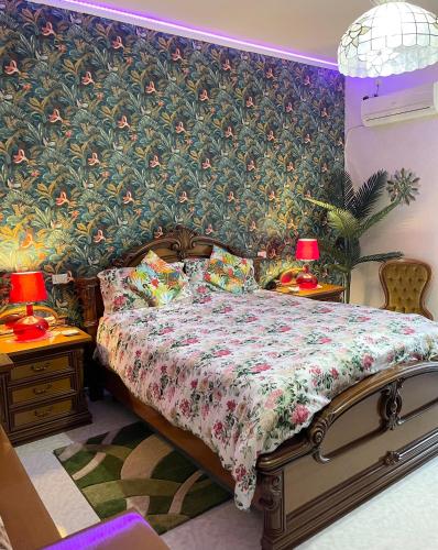 a bedroom with a bed and two tables with lamps at Home and Relax ROOMS in Furnari