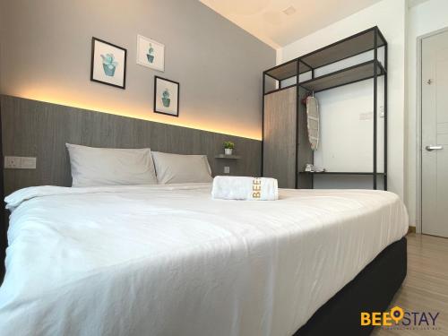 een slaapkamer met een groot wit bed en een spiegel bij The Wave Suites Melaka by BEESTAY in Melaka
