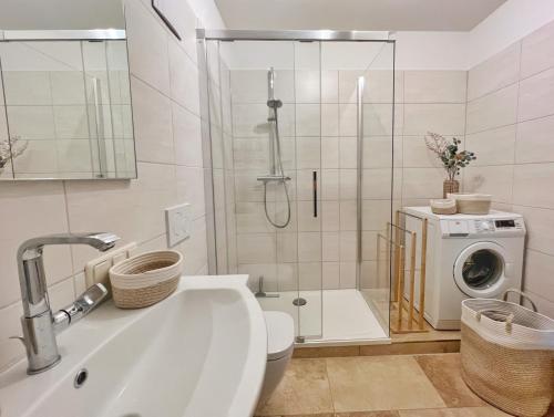 La salle de bains est pourvue d'une douche, de toilettes et d'un lave-linge. dans l'établissement TURMHAUS Whg. TH-15, à Wustrow