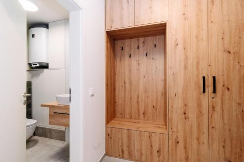 a wooden door in a bathroom with a toilet at Horský apartmán Temari 11 Klínovec in Loučná pod Klínovcem