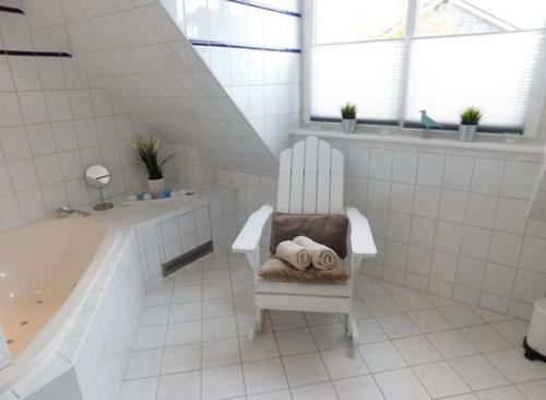 a bathroom with a tub and a chair with a towel at Ferienhaus Cozy Cottage 1 in Neue Tiefe Fehmarn