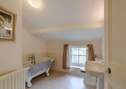 a white bathroom with a tub and a sink at Kingston House in West Witton