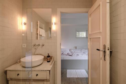 a bathroom with a white sink and a tub at Apartment im Kranich Hotel in Hessenburg