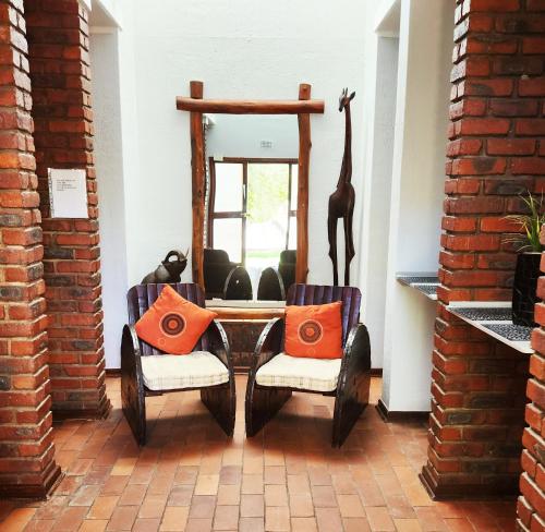 a room with a table and two chairs and a mirror at Tramonto Lodge in Upington