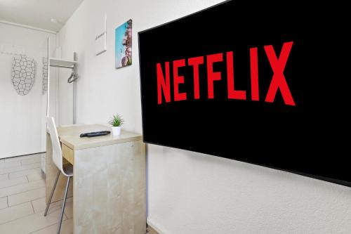 ein Netflix-Schild an einer Wand in einem Zimmer in der Unterkunft Excellent Connection-Central-Coffee-Washer in Basel