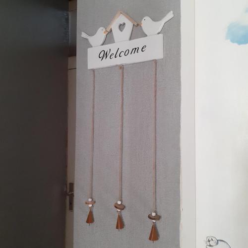 a welcome sign on a wall with birds on it at Bi uns im Norden in Brunsbüttel