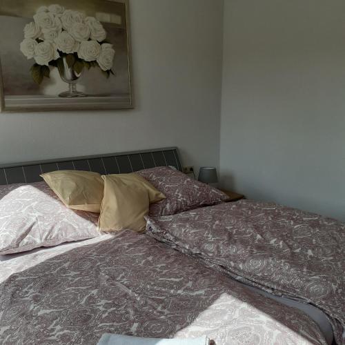 an unmade bed in a bedroom with a vase of flowers at Bi uns im Norden in Brunsbüttel