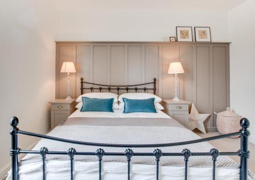 a bedroom with a large bed with blue pillows at Juniper in Whitby
