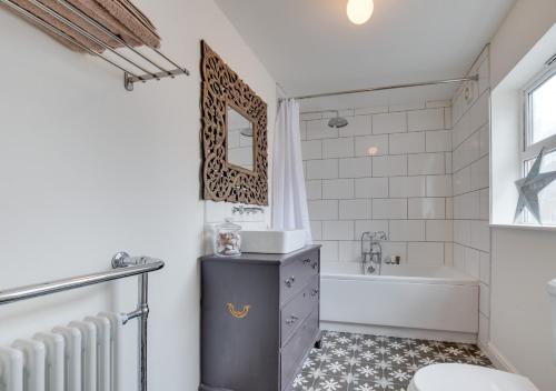 a bathroom with a tub and a sink and a toilet at Juniper in Whitby