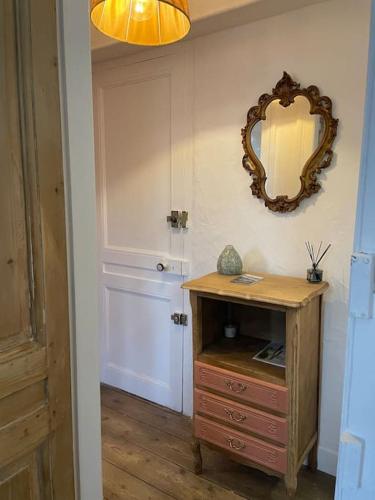 Cette chambre comprend une commode en bois et un miroir. dans l'établissement Gîte « Le Marie », à Saint-Martin-aux-Buneaux