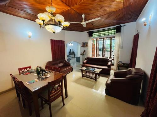 a living room with a table and leather chairs at Mangala Lodge in Kurunegala