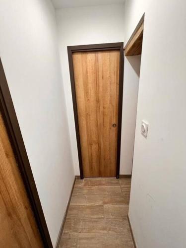 a hallway with a wooden door in a room at Beau T3 à Arcueil à 3 min RER B « Laplace » in Arcueil