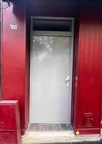 a red building with a white door on it at Beau T3 à Arcueil à 3 min RER B « Laplace » in Arcueil