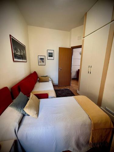 a bedroom with two beds and a red couch at Casa Fiorita in Taormina
