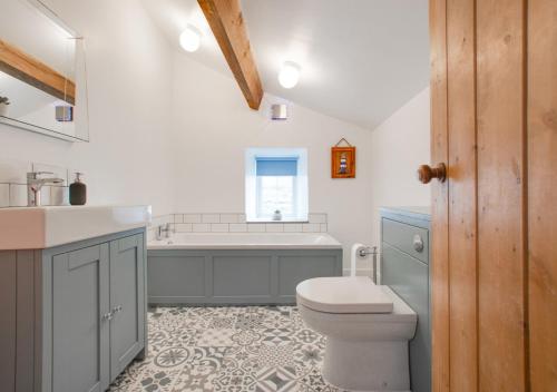 a bathroom with a toilet and a sink and a tub at Howgate Farm in Askrigg