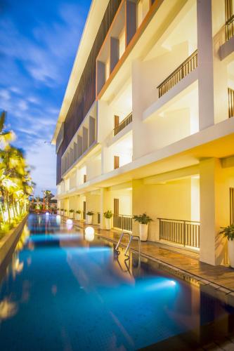 a swimming pool in front of a building at HARRIS Hotel Seminyak in Seminyak