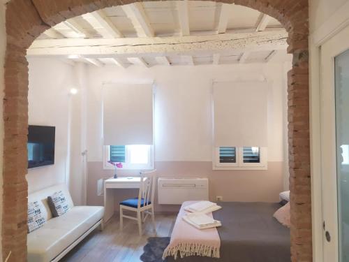 Habitación con cama, escritorio y sofá. en Appartamento in via San Gallo, en Florencia