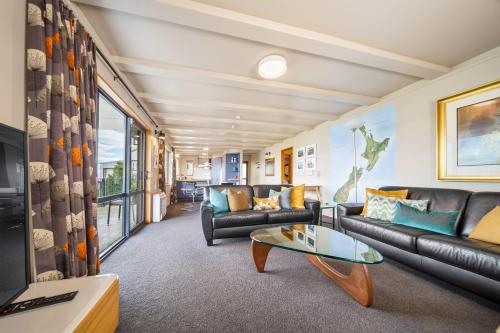 a living room with couches and a table at Whakatipu Heights in Queenstown