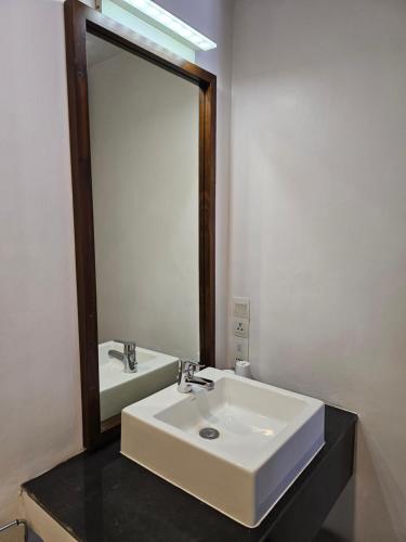 a bathroom with a white sink and a mirror at Blue Breeze - Jetwing Select in Negombo