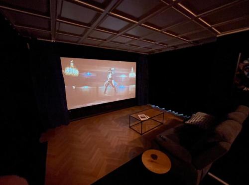 a room with a large screen with a video game at Private Spa Lodge Odenwald in Lindenfels