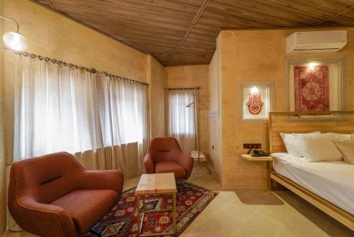 a bedroom with two chairs and a bed and a table at Henna Hotel-Adults Only in Goreme