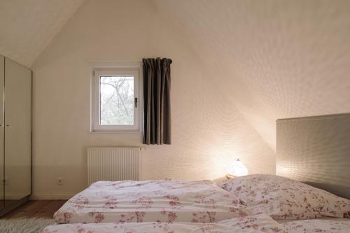 a white bedroom with a bed and a window at Apartment im Kranich Hotel in Hessenburg