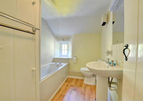 a bathroom with a tub and a sink and a toilet at Hollins Cottage in Grosmont