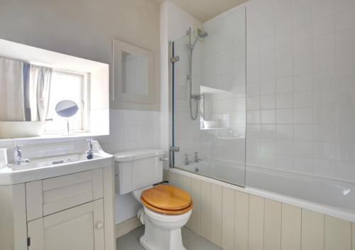 a bathroom with a toilet and a tub and a sink at Holmlea in Robin Hood's Bay