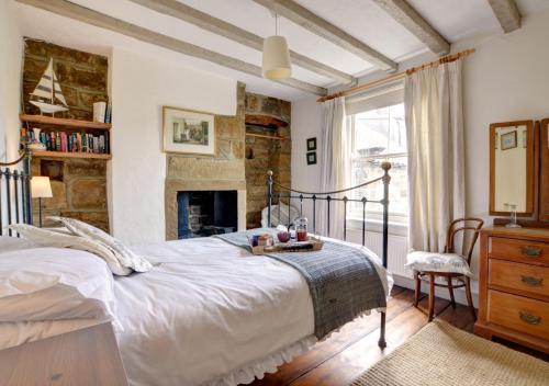 a bedroom with a large bed and a fireplace at Holmlea in Robin Hood's Bay