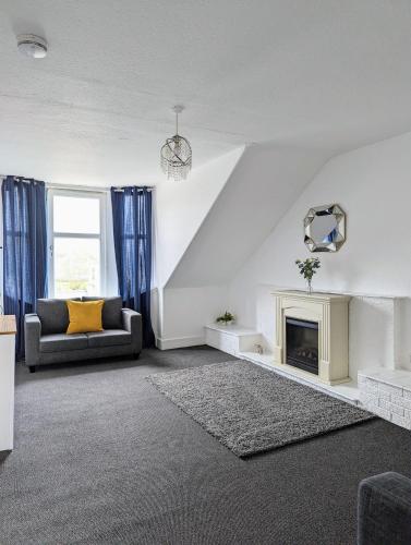 a living room with a couch and a fireplace at Campbeltown Loch in Campbeltown