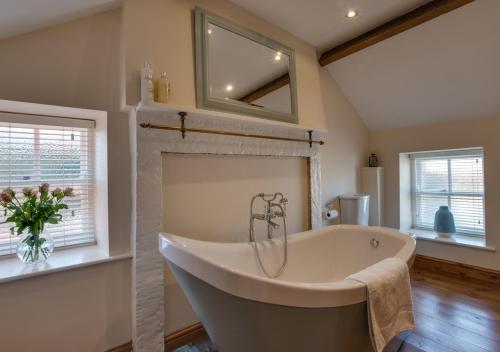 a large bathroom with a tub and windows at Holly Tree Cottage in Aislaby