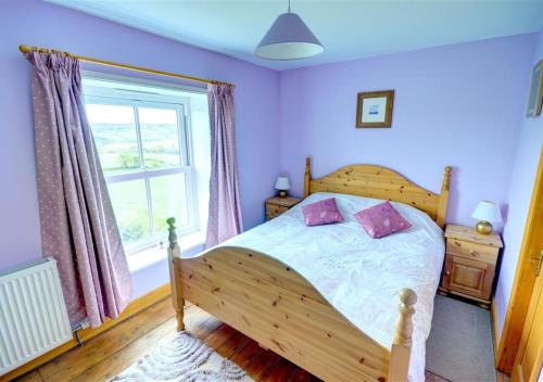 a bedroom with a wooden bed and a window at Hole In The Ellers in Lealholm