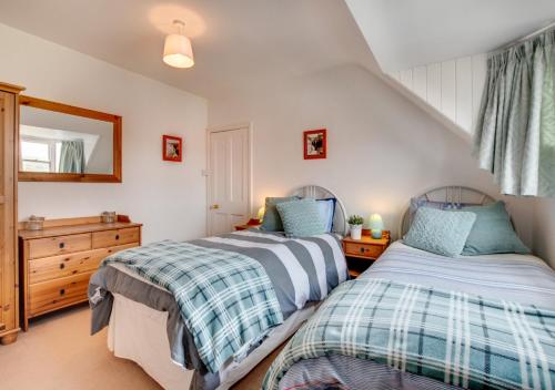 a bedroom with two beds and a mirror at Holbrooks House in Robin Hood's Bay