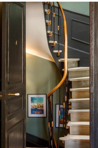a staircase in a home with a wooden rail and a stair case at Le 215 Gambetta boutique hôtel en Provence in Cavaillon