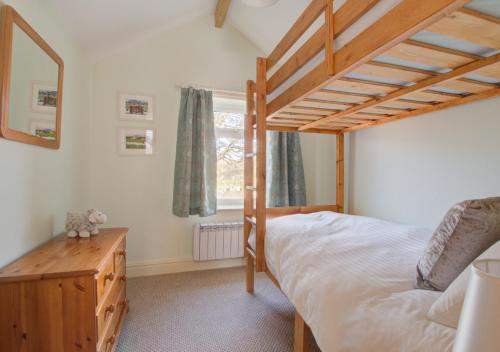 a bedroom with a wooden bunk bed and a window at Hillyard in Hawes