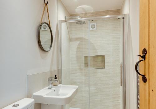 a white bathroom with a sink and a shower at Hog Barn at Howe End in Castleton