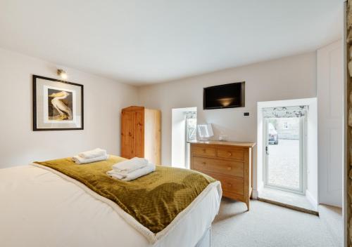 a bedroom with a bed with two towels on it at Hog Barn at Howe End in Castleton