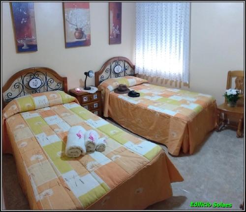 duas camas com bichos de peluche sentados numa sala em Apartamento Solaes Climatizado em Benicarló