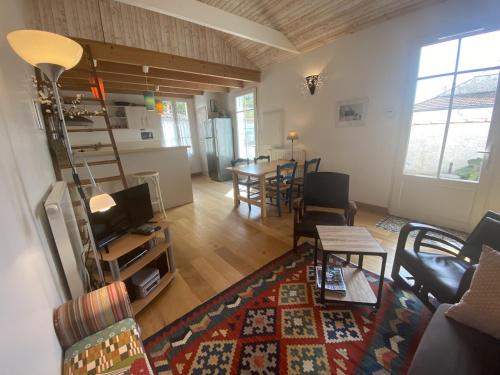 un salon avec un canapé et une table dans l'établissement Villa rénovée à Fouras: 2 ch + mezzanine, proche plage/centre, jardin privatif, équipement complet - FR-1-709-64, à Fouras