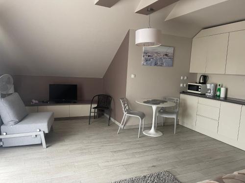 a kitchen and living room with a table and chairs at Apartament Tignes Czarna Góra in Sienna