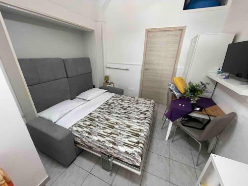um quarto com uma cama, uma secretária e uma televisão em Chez Elle - Casa vacanze zona centro em Catânia