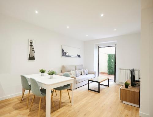 a white living room with a table and a couch at Olatu by Basque Homes in San Sebastián