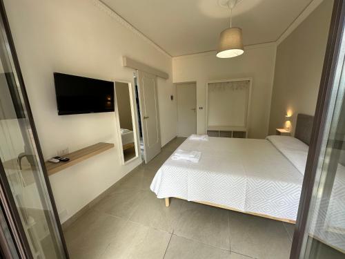 a bedroom with a bed and a flat screen tv at MIRA taormina rooms in Taormina