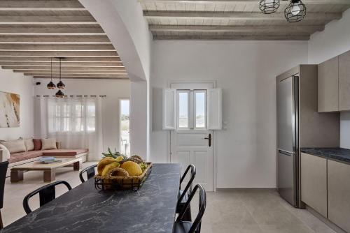 a kitchen and dining room with a table with a basket of fruit at Philippi Villa in Mýkonos City
