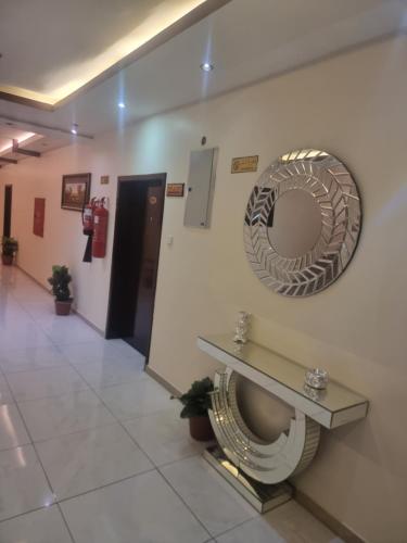 La salle de bains est pourvue d'un miroir et de toilettes murales. dans l'établissement واحه مسكنا للشقق المخدومة, à Khamis Mushait