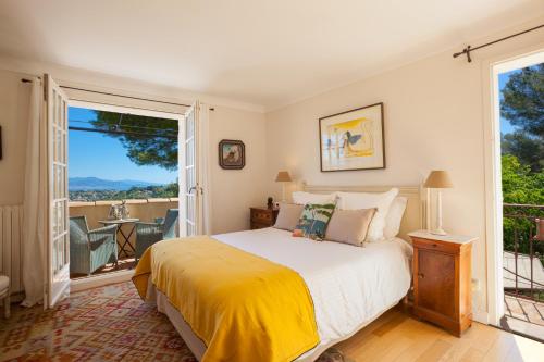 Villa Le Port d'attache في فالوريس: غرفة نوم بسرير كبير وبلكونة