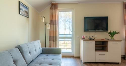 a living room with a blue couch and a tv at Ledan in Chłopy