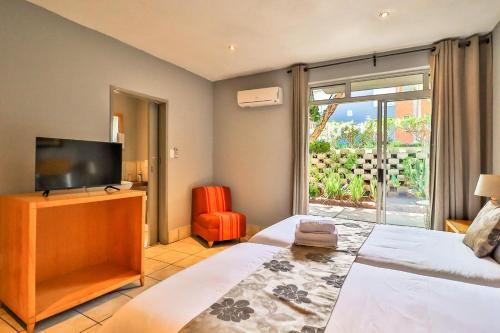 a bedroom with a bed and a flat screen tv at Villa Paradiso in Hartbeespoort
