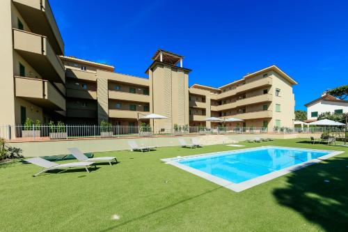 ein großes Gebäude mit Pool und einigen Gartenstühlen in der Unterkunft Residence San Francesco in Tirrenia