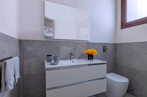 a bathroom with a white sink and a toilet at Casa B, Room 3 - Palm Kite Paradise in Marsala